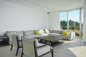 Interior of light spacious living room with large panoramic windows in a luxury villa