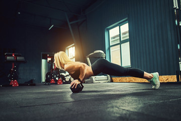 Young athletic girl doing stretching exercises in the modern gym.