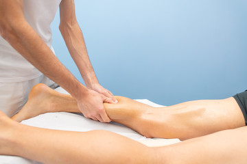 Obraz na płótnie Canvas Calf massage to an athlete by a professional physiotherapist