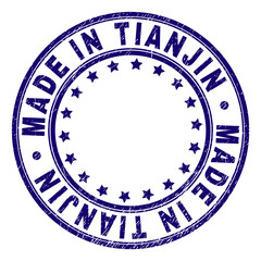 MADE IN TIANJIN stamp seal watermark with distress texture. Designed with round shapes and stars. Blue vector rubber print of MADE IN TIANJIN title with grunge texture.