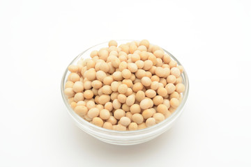 Soja amarilla cruda en un bol de cristal sobre fondo blanco