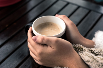 hands in a hot cup of coffee