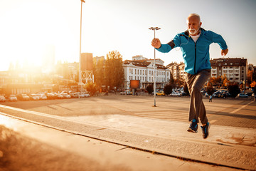 Full of energy,senior man running in city