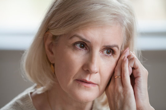 Close up of sad aged female thinking about past, missing husband or beloved man, upset senior married woman grieve or lost in thoughts, thoughtful elderly lady worry for children or having problems
