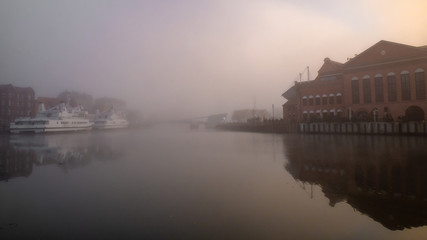 Obraz premium Motlawa River embankment in Gdansk, misty weather.