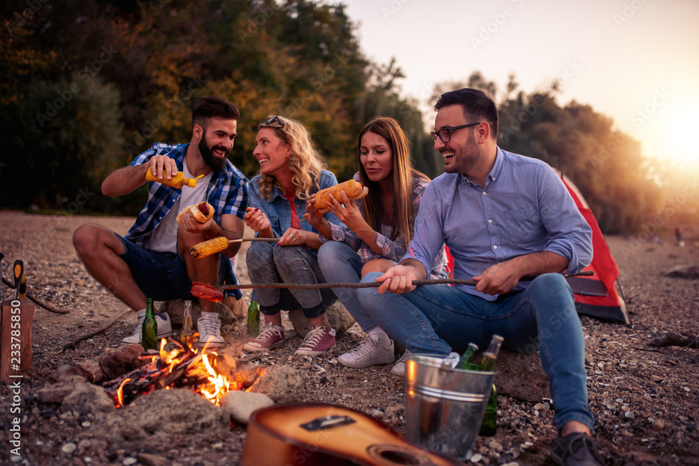 Wall mural Friends enjoying on the beach at night