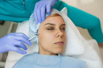 top view of eye augmentation procedure on a young woman done by a cosmetologist doctor with...