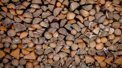 Material for heating the house. Preparation of firewood for the winter. background of firewood. A pile of firewood