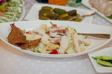Plate with chicken salad on table. Catering service. Restaurant table with food. Huge amount of food on the table. Plates of food