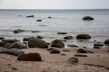 Fototapeta na wymiar rocky coastline in Latvia with flow water in the sea and large rocks
