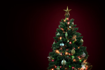 view of nice decorated christmas tree on deep red back