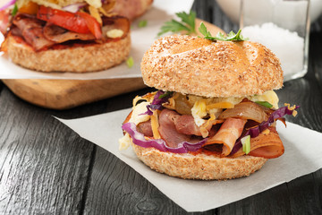 Sandwiches with fried bacon ,vegetables and fried egg on wooden board