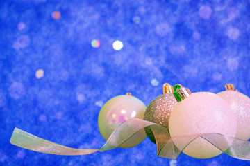 Silver and white Christmas balls in blue background with bokeh effect and copy space