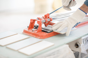 Close-up of a man cutting ceramic tiles with handy machine