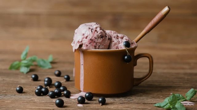 Cinemagraph - Currant ice cream in cup on wooden table. Drops of ice cream dripping . Motion Photo.