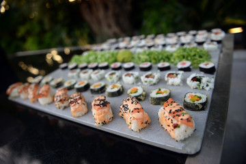 Kinds of sushi on a gray tray.