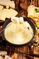 Gourmet Swiss fondue dinner on a winter evening with assorted cheese