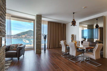 Interior of light spacious living room with large panoramic windows in a luxury villa