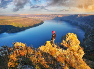 tourist on the mountain above the river. the girl looks at the picturesque canyon. autumn morning on the river Dniester