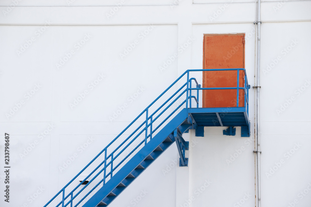 Wall mural red steel door and blue metal fire exit stair of factory.