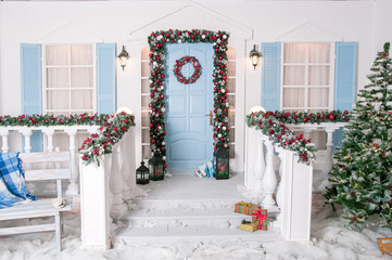 New Year's interior. Decoration of the house. White skates on the door. Nutcracker. Firs near the house. The bench is wooden.