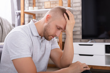 Upset Man Sitting On Sofa