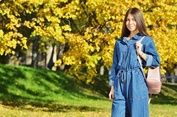 Hiking girl in autumn Park. Girl tourist looking around in the Park