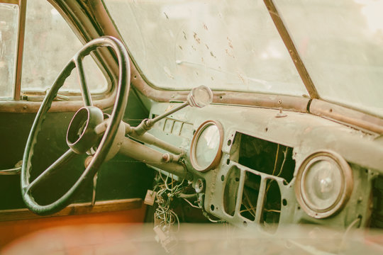 Old photo of Old timer car interior with dusty board and spider web all over the dashboard with rusty levers