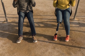 Couple playing on playground swing