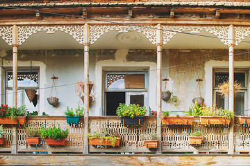 Old House in Tbilisi, Georgia with Beautiful Terrace. Ancient traditional wooden balcony decorated with lot of flowers and old artifacts