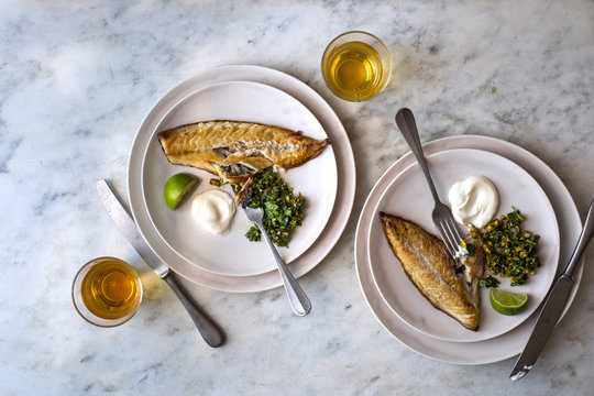 Overhead view of mackerel with pistachio and cardamom salsa served on plate