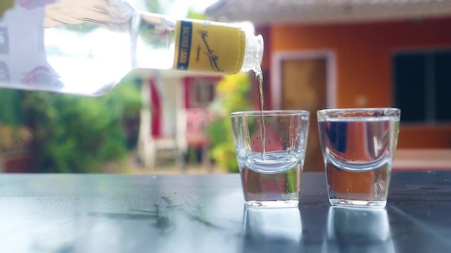 Pouring 'Bacardi White Rum' to Vodka Glasses, Slow Motion Shot