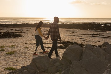 Couple holding hands and walking on beach