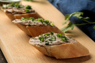 Fresh homemade chicken liver pate with greens on bread on a dark background. A sandwich. close-up