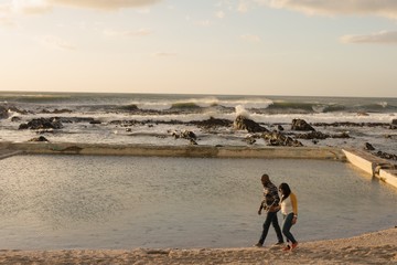 Couple holding hands and walking on promenade