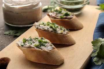 Fresh homemade chicken liver pate with greens on bread on a dark background. A sandwich. close-up