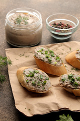 Fresh homemade chicken liver pate with greens on bread on a dark background. A sandwich.