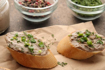 Fresh homemade chicken liver pate with greens on bread on a dark background. A sandwich. close-up