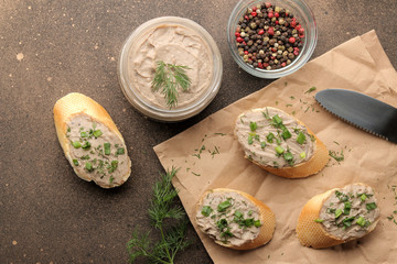 Fresh homemade chicken liver pate with greens on bread on a dark background. view from above