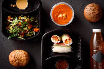 rolls of rice paper with vegetables, tomato soup and vegetable salad with a drink. Healthy food delivery. Take away for diet. Fitness nutrition, vegetable, fruits in eco boxes.