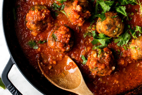 Close up of fish koftas in tomato and cardamom sauce