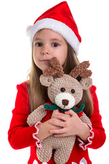 Girl huggs the deer soft toy, wearing a santa costume isolated over a white background