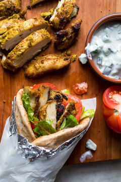 Close up of meat wrap with yogurt sauce on cutting board