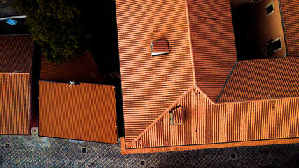 Perpendicular aerial view on the roof of a building, built with red tiles, in Rome, Italy. To the...