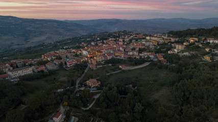 Fototapeta premium Aerial view at sunset of the small town of Montecalvo Irpino, in the province of Avellino, in Italy. This village with few houses and streets is built in the mountains of Irpinia.