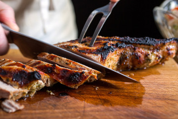 Close up of knife cutting roasted pork