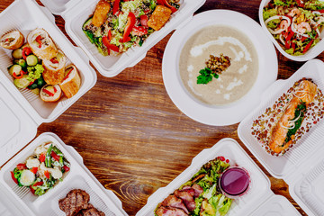 Healthy food delivery. Take away for diet. Fitness nutrition, vegetables, meat and fruits in white eco boxes. Top view, flat lay at natural wood with copy space