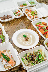 Healthy food delivery. Take away for diet. Fitness nutrition, vegetables, meat and fruits in white eco boxes. Top view, flat lay at natural wood with copy space