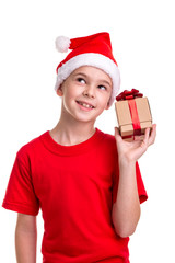 Happy boy, santa hat on his head, received the small gift box in the hand. Concept: christmas or Happy New Year holiday