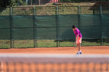 Young tennis player serving the ball